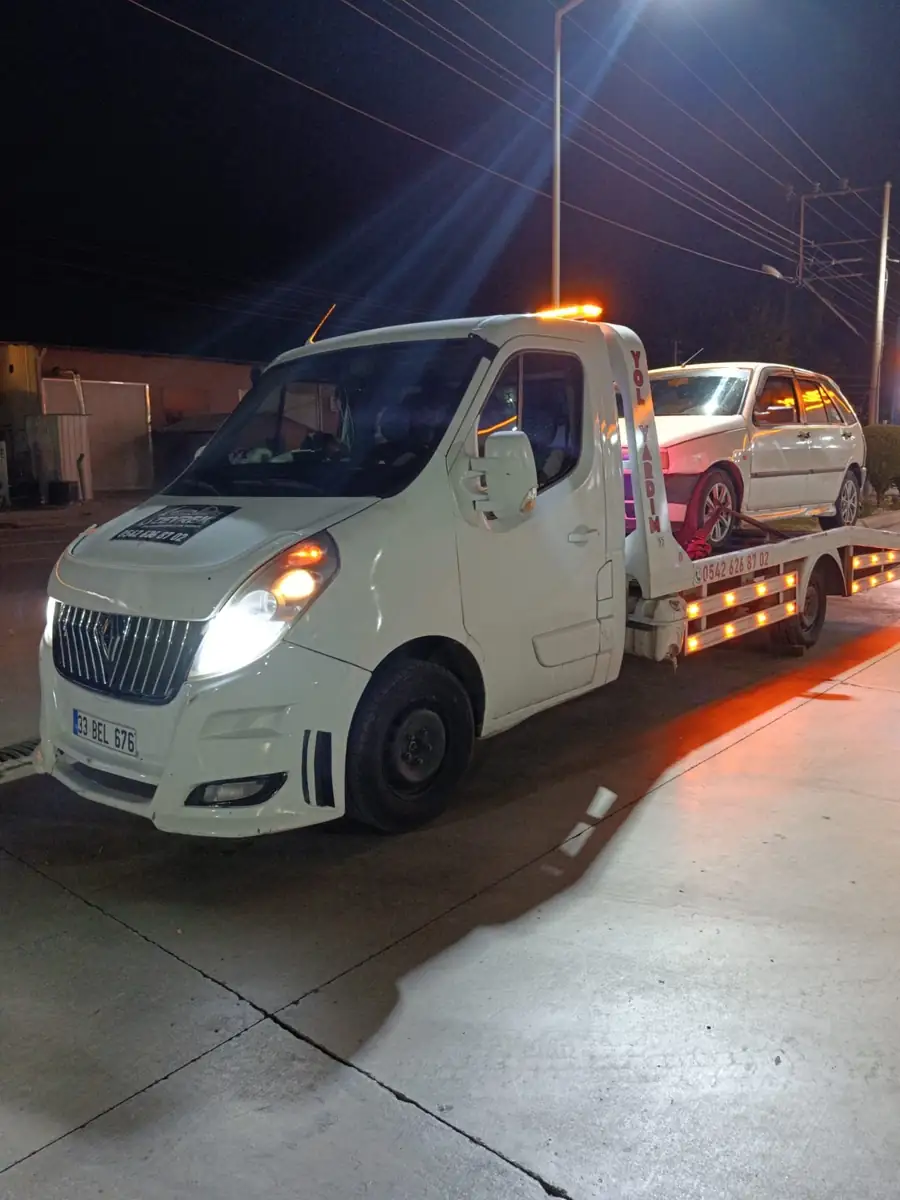 Antalya’da gece, sarı uyarı lambaları yanan Zeyrek Oto Çekici kayar platformunda beyaz bir otomobil taşıyor